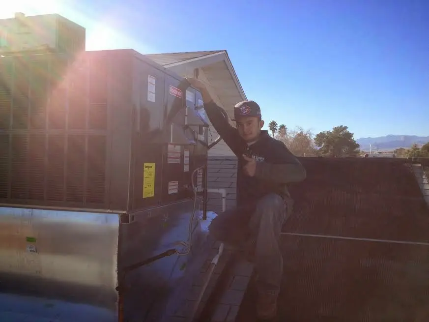 HVAC technician performing Boiler Repair on a rooftop unit in Woodfin